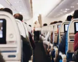 Wnętrze samolotu, pasażerowie siedzą w rzędach. Zastanawiasz się, czy po wyrwaniu zęba można lecieć samolotem?