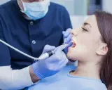 Dentysta wykonuje zabieg. Zastanawiasz się, ile kosztuje znieczulenie u dentysty? To zależy od rodzaju i gabinetu.